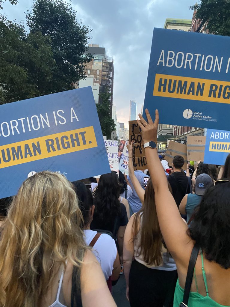Global Justice Center staff hold up signs at a protest against the United States Supreme Court's 2022 ruling against abortion rights.